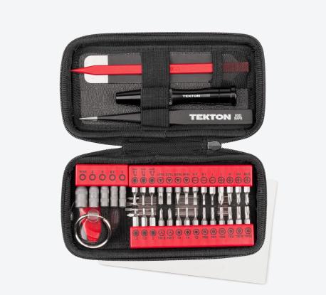 Tekton bit sets and tech repair tools laid flat in an open black case on top of a white parts mat.