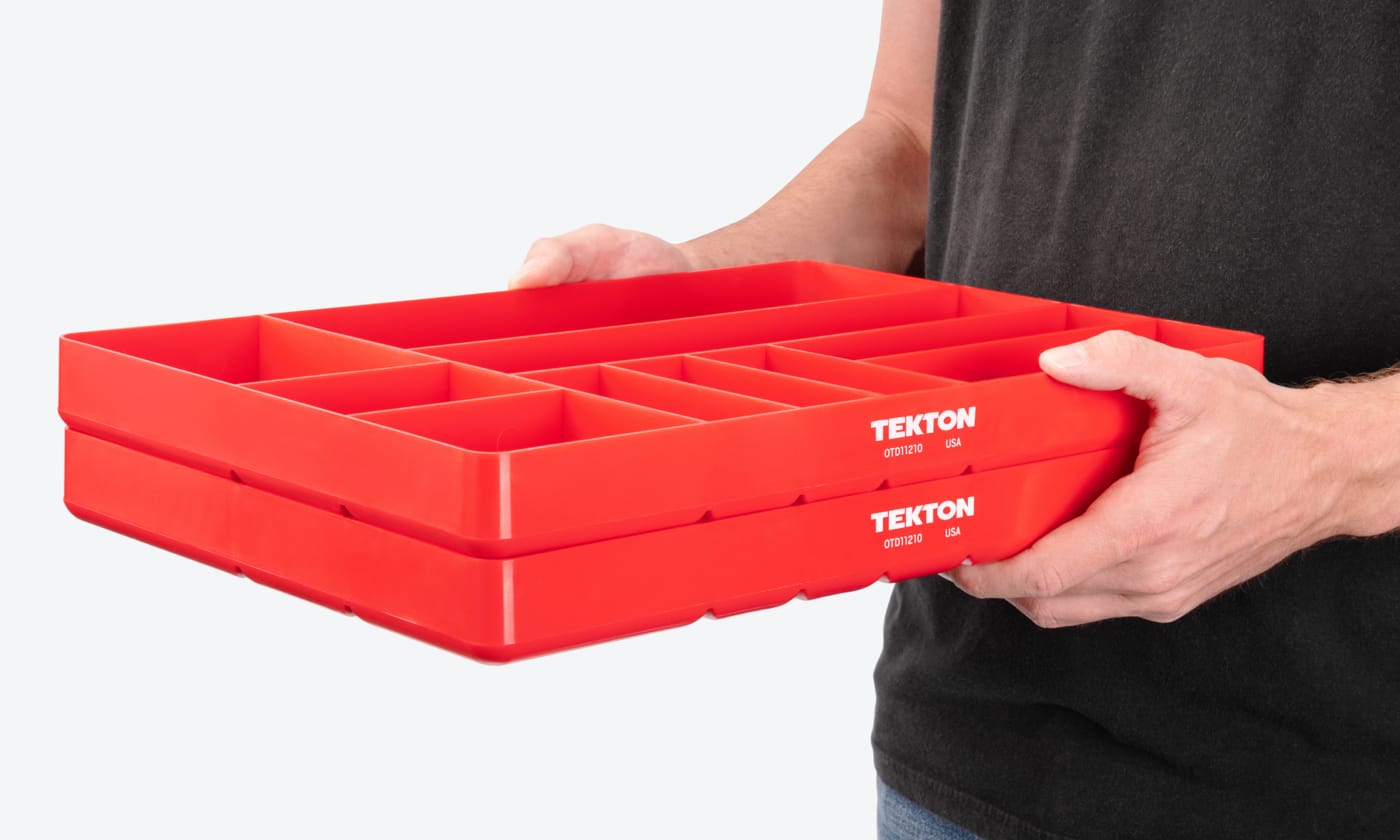 A person holding two TEKTON Organization Trays stacked together